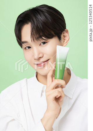 A young man posing with basic cosmetics made using plants 125340514