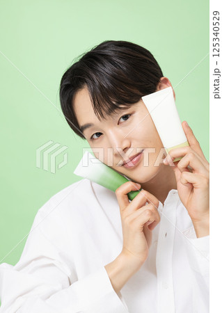 A young man posing with basic cosmetics made using plants 125340529