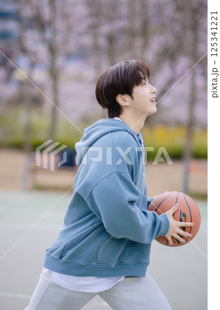 Portrait of a young man playing basketball in the park 125341221