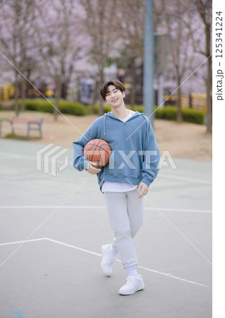 Portrait of a young man playing basketball in the park Portrait of a young man playing basketball in the park 125341224