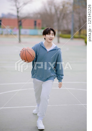 Portrait of a young man playing basketball in the park Portrait of a young man playing basketball in the park 125341226