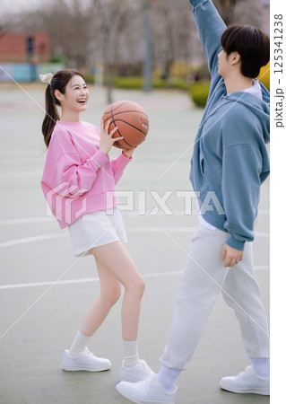 A young couple enjoying a basketball date in the park 125341238