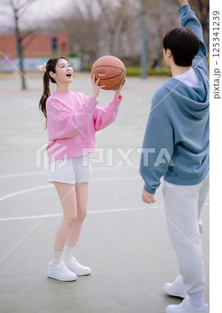 A young couple enjoying a basketball date in the park 125341239