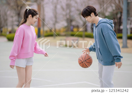 A young couple enjoying a basketball date in the park 125341242