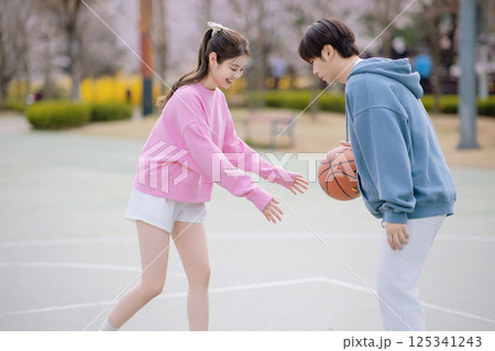 A young couple enjoying a basketball date in the park 125341243