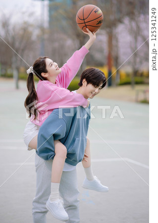 A young couple enjoying a basketball date in the park A young couple enjoying a basketball date in the park 125341249