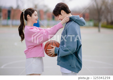 A young couple enjoying a basketball date in the park 125341259