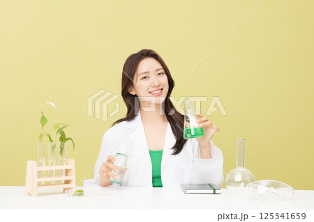A woman wearing a doctor's gown is holding eco-friendly cosmetics A woman wearing a doctor's gown is holding eco-friendly cosmetics 125341659