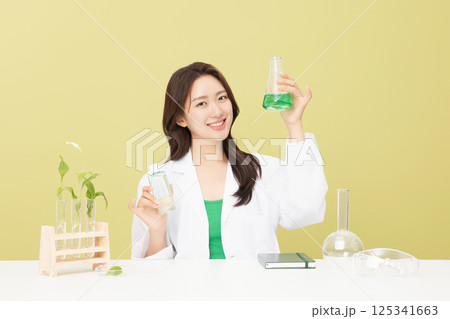 A woman wearing a doctor's gown is holding eco-friendly cosmetics A woman wearing a doctor's gown is holding eco-friendly cosmetics 125341663