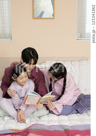 A family gathered in the living room doing their own thing 125341862