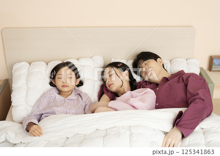 A family gathered in the living room doing their own thing 125341863