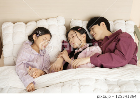 A family gathered in the living room doing their own thing A family gathered in the living room doing their own thing 125341864