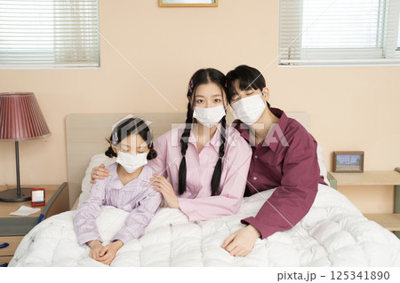 A family of three sitting affectionately together on the living room sofa A family of three sitting affectionately together on the living room sofa 125341890