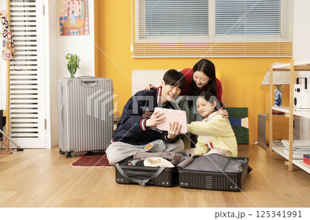 Extroverted family sitting on the sofa and taking a selfie together 125341991