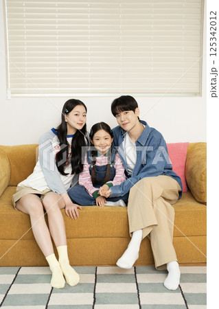 A young couple lovingly looking at their daughter lying on the floor 125342012