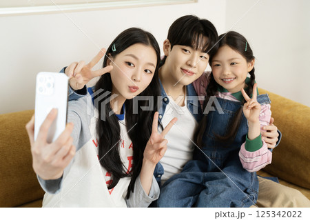 Daughter building domino blocks with her mother and father lying on the sofa 125342022