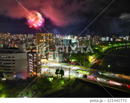甲突川沿いから鹿児島市のビル群に浮かぶ花火の空撮 125342773