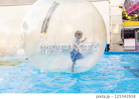 Child playing inside water walking ball 125342938
