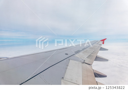 View from the airplane window at a beautiful cloudy sky and the airplane wing 125343822