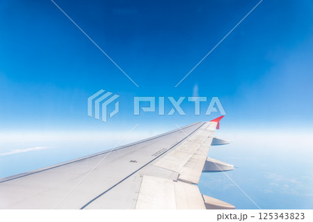 View from the airplane window at a beautiful cloudy sky and the airplane wing 125343823