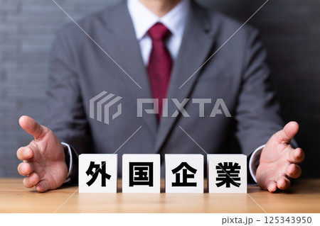 外国企業のブロックとスーツを着たミドル男性ビジネスマン 外国企業のブロックとスーツを着たミドル男性ビジネスマン 125343950