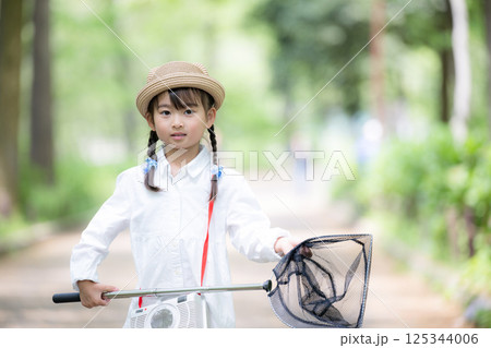 虫むし大作戦！　虫網で森の中で虫を捕まえる、女の子の夏休み　夏の子供のレジャーや冒険のイメージ 125344006