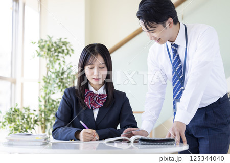 塾で勉強する高校生と講師 塾で勉強する高校生と講師 125344040