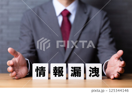 情報漏洩のブロックとスーツを着たミドル男性ビジネスマン 情報漏洩のブロックとスーツを着たミドル男性ビジネスマン 125344146