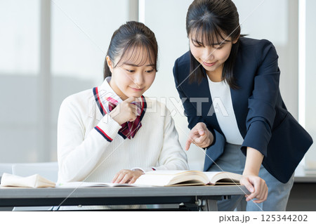 塾で勉強する女子高生と先生　撮影協力：学校法人電波学園　東京電子専門学校 125344202
