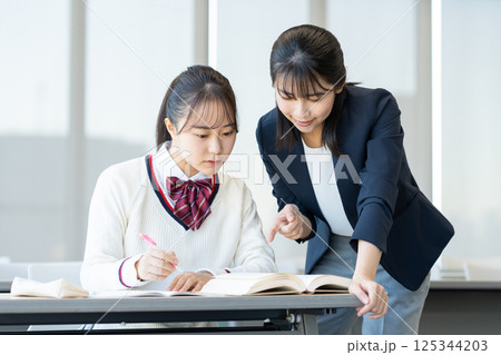 塾で勉強する女子高生と先生　撮影協力：学校法人電波学園　東京電子専門学校 125344203