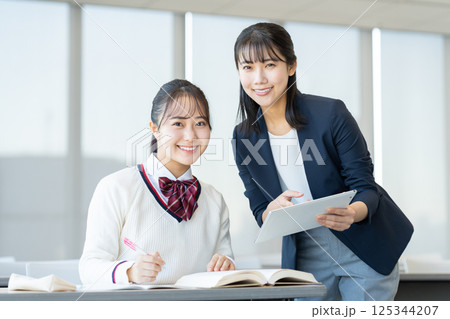 塾で勉強する女子高生と先生　撮影協力：学校法人電波学園　東京電子専門学校 125344207