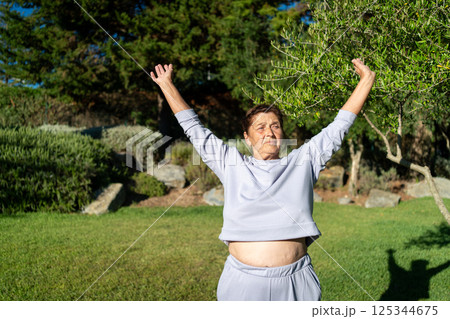 Determined senior lady stretching arms in sunny 125344675