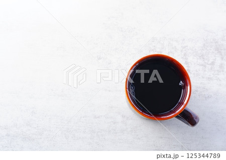 淹れたてのコーヒーが入ったマグカップを、真上から俯瞰したイメージ 淹れたてのコーヒーが入ったマグカップを、真上から俯瞰したイメージ 125344789