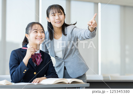 塾で勉強する女子高生と先生 撮影協力:学校法人電波学園 東京電子専門学校 塾で勉強する女子高生と先生 撮影協力:学校法人電波学園 東京電子専門学校 125345380