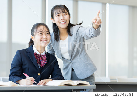 塾で勉強する女子高生と先生 撮影協力:学校法人電波学園 東京電子専門学校 塾で勉強する女子高生と先生 撮影協力:学校法人電波学園 東京電子専門学校 125345381