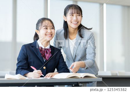塾で勉強する女子高生と先生 撮影協力:学校法人電波学園 東京電子専門学校 塾で勉強する女子高生と先生 撮影協力:学校法人電波学園 東京電子専門学校 125345382