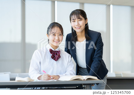 塾で勉強する女子高生と先生 撮影協力:学校法人電波学園 東京電子専門学校 塾で勉強する女子高生と先生 撮影協力:学校法人電波学園 東京電子専門学校 125345700