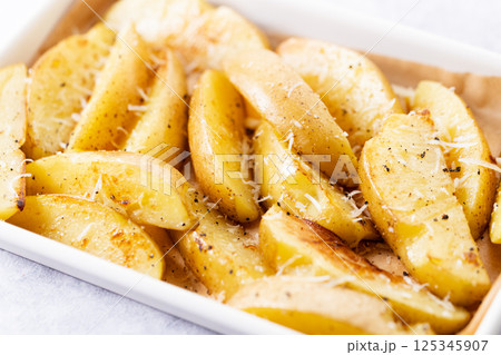 Baked potato wedges with cheese. Baked potato wedges with cheese. 125345907