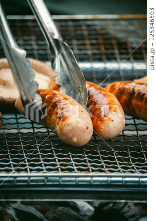 キャンプの主役：ジューシーなグリルソーセージ 125346503