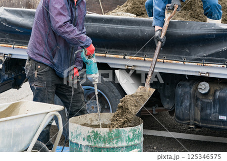 コンクリートを練る土木作業員 125346575