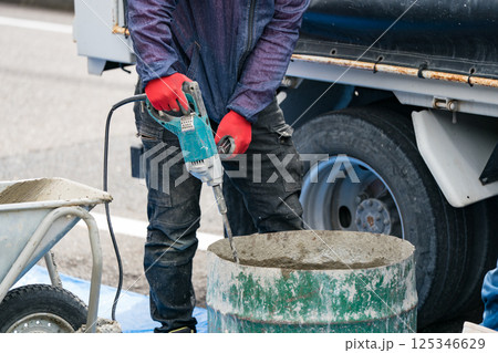 カクハン機でコンクリートを練る土木作業員 125346629