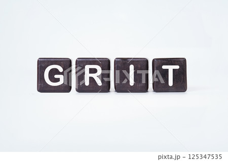 Letters Arranged to Spell Grit on a Neutral Background Highlighting Determination and Strength in Challenges 125347535
