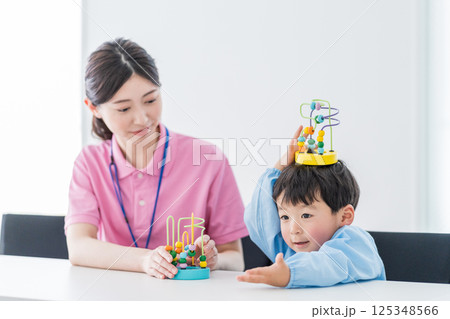 知育玩具でトレーニングする保育園児と保育士 125348566