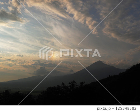 初夏の夕暮れ時、夕日で現れた彩雲とシルエットの磐梯山とのコントラストが印象的で綺麗だ。 初夏の夕暮れ時、夕日で現れた彩雲とシルエットの磐梯山とのコントラストが印象的で綺麗だ。 125348582
