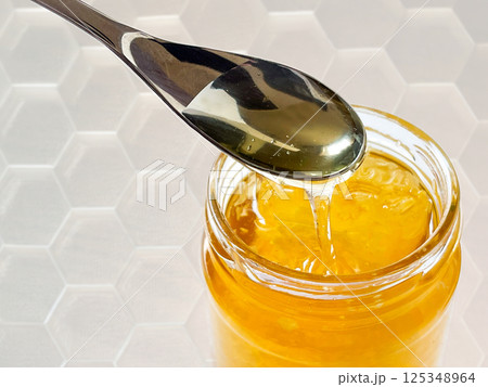 蜂蜜をスプーンですくう 六角形の影模様 蜂蜜をスプーンですくう 六角形の影模様 125348964