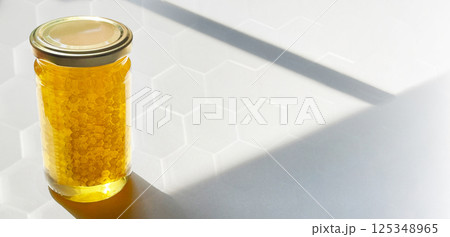 ハチの巣入り蜂蜜の瓶と六角形の柄 ハチの巣入り蜂蜜の瓶と六角形の柄 125348965