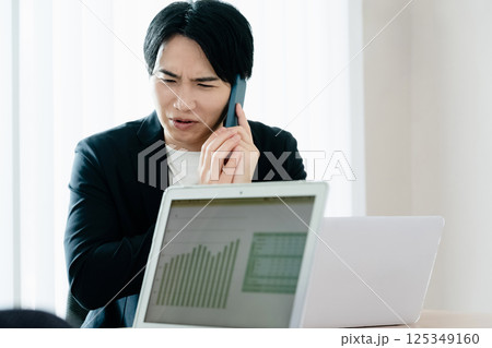 スマホで通話するカジュアルスタイルのビジネスマン 125349160