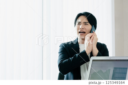 スマホで通話するカジュアルスタイルのビジネスマン 125349164