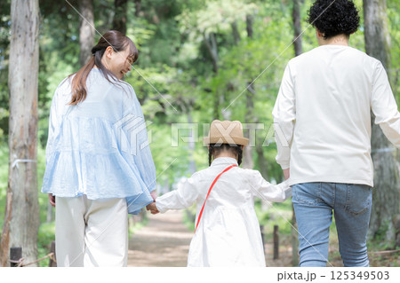 家族で夏休みの虫探し！お出かけやレジャーのイメージ　森で楽しそうなファミリー歩く顔なし後ろ姿 125349503
