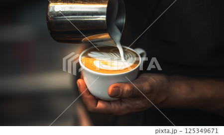barista hand pouring milk for making latte art in cafe 125349671